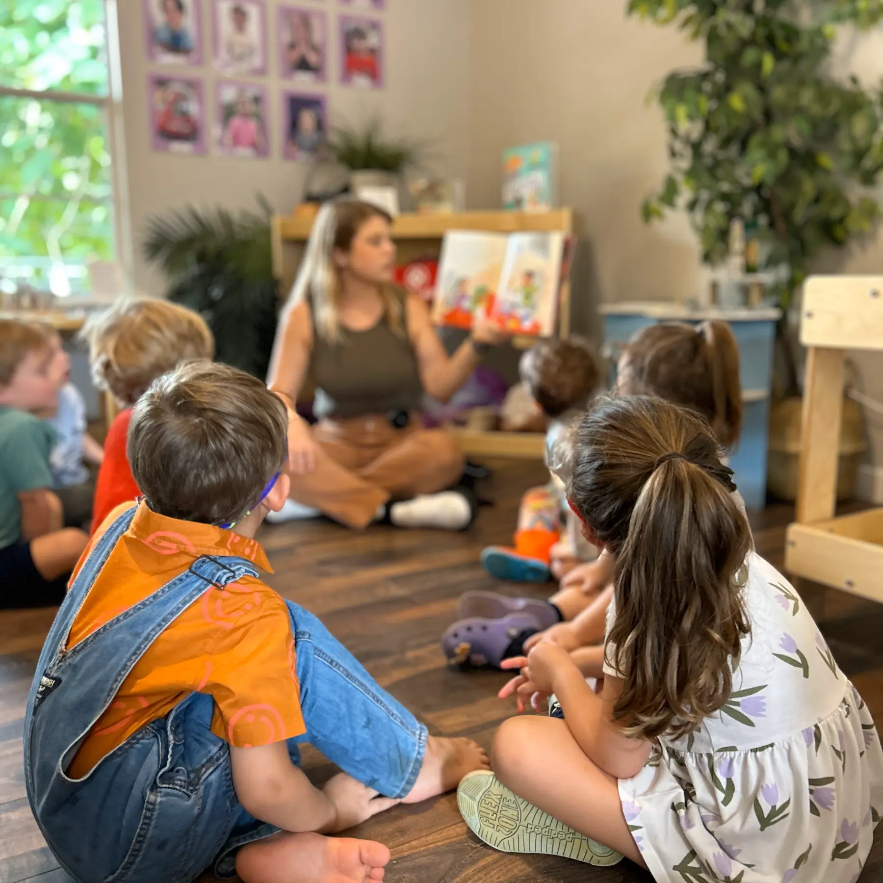 A Mockingbird teacher reading with a small group of preschoolers in the classroom